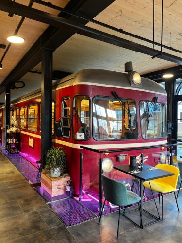 a red train car in a room with tables and chairs at Ferienbahnhof Reichenbach in Dahn
