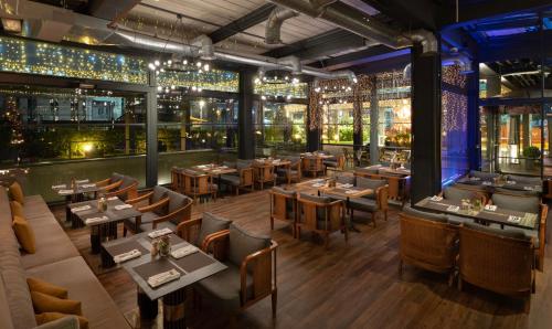 a restaurant with tables and chairs and lights at Movenpick Living Istanbul West in Istanbul