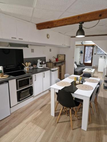 une cuisine et un salon avec une table et des chaises dans l'établissement Spacious village house completely renovated, à Pennautier