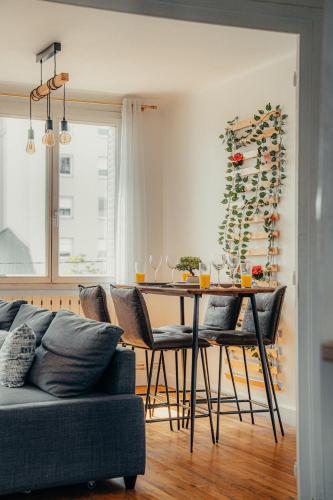 - une salle à manger avec une table, des chaises et des bouteilles de vin dans l'établissement Le cocon logement pour 6 et 1 bébé, à Villeurbanne