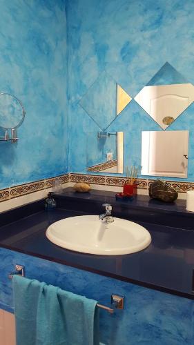 a blue bathroom with a sink and a mirror at Hostal A La Sombra Del Laurel in Navarrete