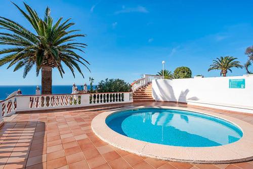 une piscine dans un patio avec un palmier dans l'établissement Alta Mar Apartment, à Son Bou