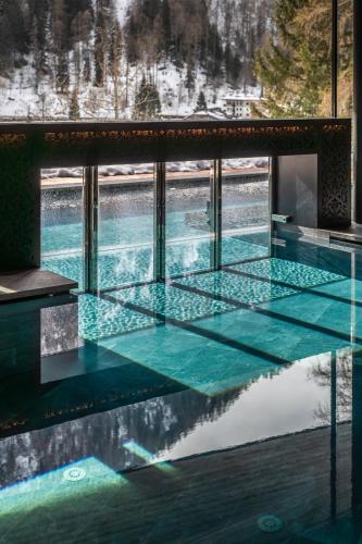 a swimming pool with a reflection in the water at Hotel Vioz in Peio Fonti