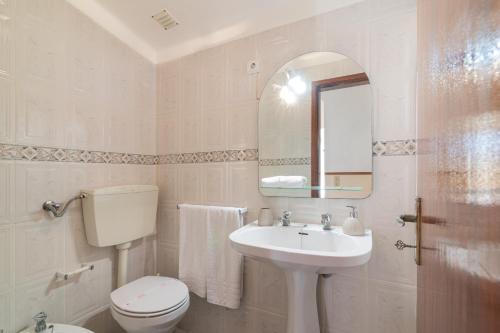 un bagno con un water, un lavandino e uno specchio di Casa Do Sol - Estombar Algarve a Estômbar
