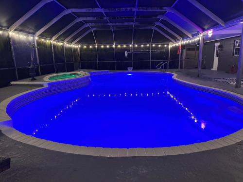 a large swimming pool in a building with blue lighting at Tampa Luxury 5BR Estate with Pool and Golf Views in Tampa