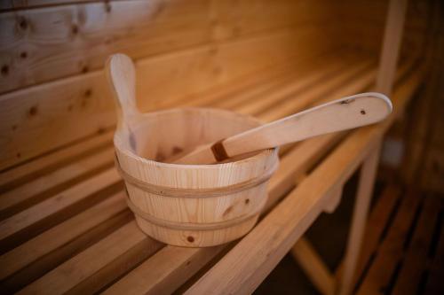 a wooden bucket with a wooden spoon on a wooden table at Willa Aleksandria in Grabie