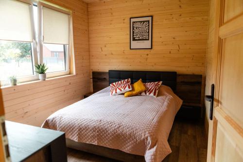 a bedroom with a bed in a wooden room at Willa Aleksandria in Grabie