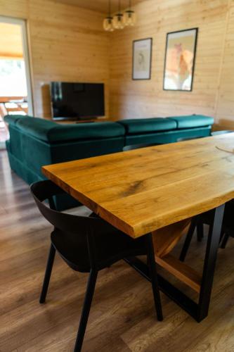 a wooden table in a room with a couch at Willa Aleksandria in Grabie