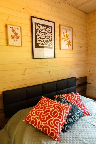 a bed in a room with two pictures on the wall at Willa Aleksandria in Grabie