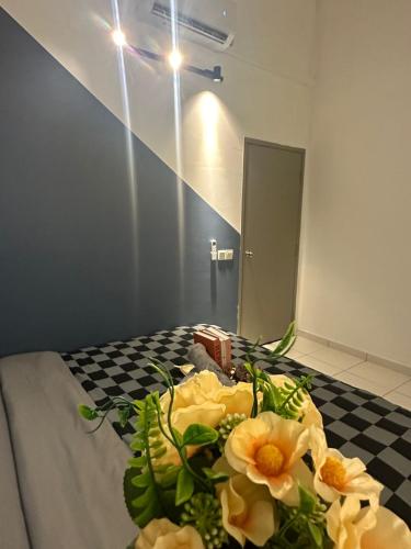 a bouquet of flowers on a bed in a room at Jalan Rambai 9 Family Suite 3 Bedroom in Pasir Gudang