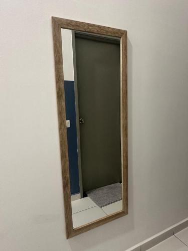 a mirror with a wooden frame on a wall at Jalan Rambai 9 Family Suite 3 Bedroom in Pasir Gudang