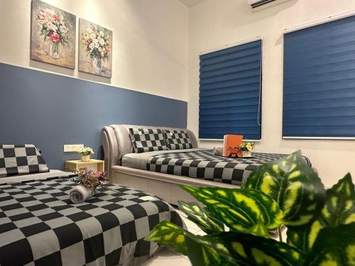 a room with two beds and a couch and windows at Jalan Rambai 9 Family Suite 3 Bedroom in Pasir Gudang
