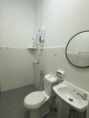 a white bathroom with a toilet and a sink at Jalan Rambai 9 Family Suite 3 Bedroom in Pasir Gudang