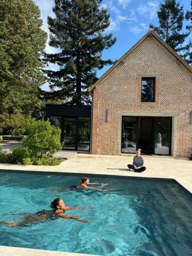 - 2 personnes dans une piscine dans une maison dans l'établissement Chateau et piscine privé près du Chateau de Chambord, à Lanthenay