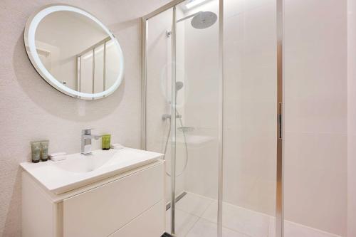 une salle de bain blanche avec un lavabo et un miroir dans l'établissement Superb apartment with terrace 2BR 4P Trocadero, à Paris