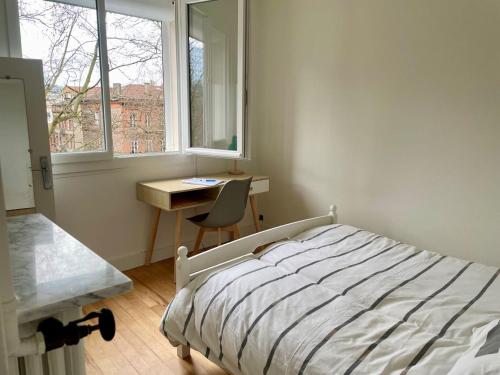 une chambre avec un lit, un bureau et une fenêtre dans l'établissement Casual, à Toulouse