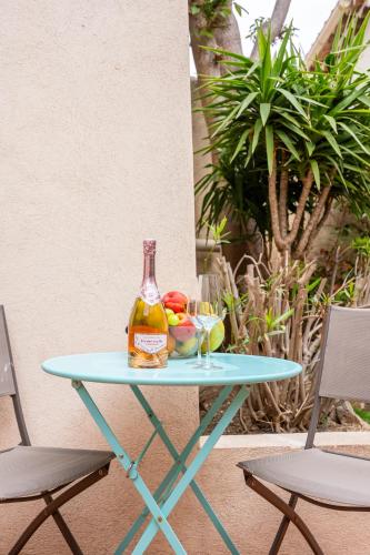 - une bouteille de vin sur une table avec 2 chaises dans l'établissement Le cocon de Vauban, à Marseille