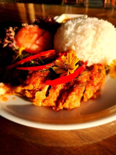 a plate of food with rice and a flower on it at RoomQuest THEVA Resort Koh Samui in Koh Samui 