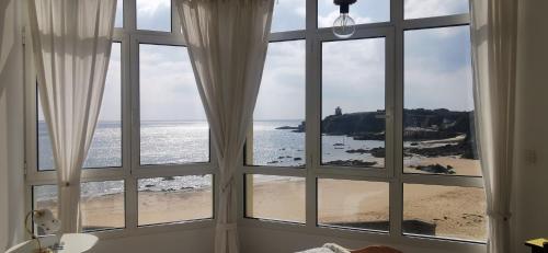 a room with a window looking out at the beach at T3 lumineux, vue mer, 74m2 in Clohars-Carnoët
