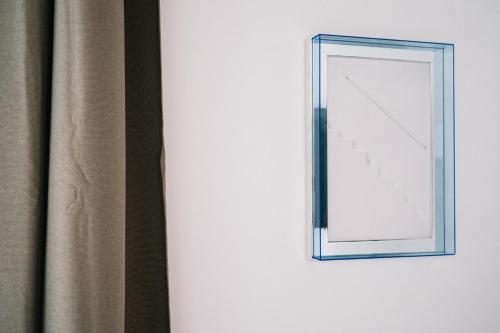 a mirror on a wall next to a curtain at La Bianca Dimora B&B in Gioia del Colle