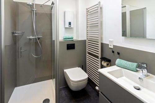 ein Badezimmer mit Dusche, Toilette und Waschbecken in der Unterkunft Ferienhaus Kim in Dornumersiel