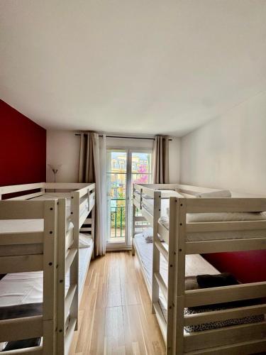 une chambre avec quatre lits superposés et une fenêtre dans l'établissement Disney, very nice 2 bedrooms family apartment, wifi, NETFLIX 8 pers, à Chessy