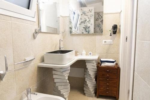 a bathroom with a sink and a toilet at Villa Adele Eleganza & Comfort in Pachino