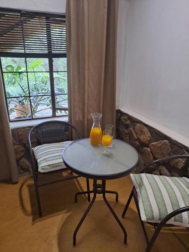 two glasses of orange juice on a table in a room at LittleBush Private Lodge in Hoedspruit