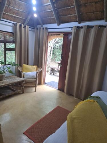 a living room with a door open to a patio at LittleBush Private Lodge in Hoedspruit
