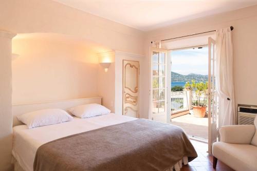 une chambre blanche avec un lit et un balcon dans l'établissement Magnifique maison avec piscine - 5BR-10P - Gassin, à Saint-Tropez