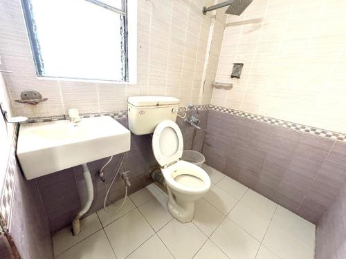 a bathroom with a toilet and a sink at Sea Sand Digha in Digha