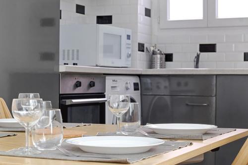 une cuisine avec une table avec des assiettes et des verres à vin dans l'établissement Daumesnil Gare de Lyon II Appartement Cosy 1BR, à La Celle-sous-Gouzon