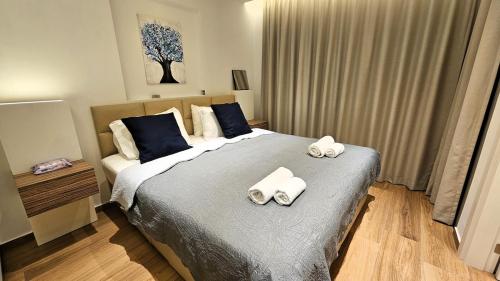 a bedroom with a bed with two towels on it at The Suave - Limassol City Centre Luxury in Limassol