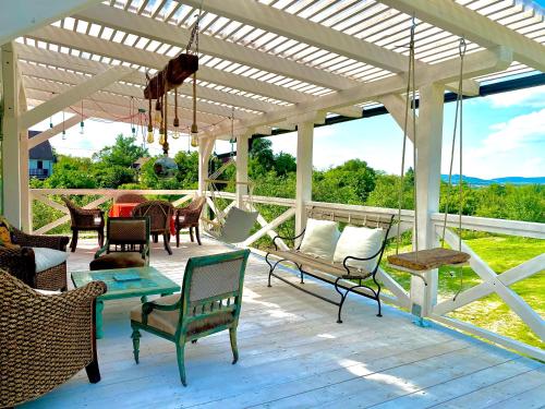 a patio with chairs and a swing on a deck at Tiny House at lake Balaton in Kisapáti