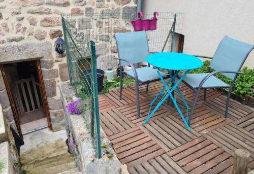 a patio with a blue table and chairs on it at Studio AL'escapade in Saint-Chély-dʼApcher