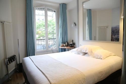 a bedroom with a large bed with a large window at Stella Etoile in Paris