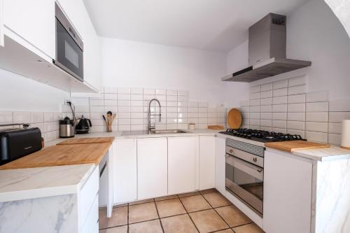 a kitchen with white cabinets and a stove top oven at Villa Alba in Santa Eularia des Riu