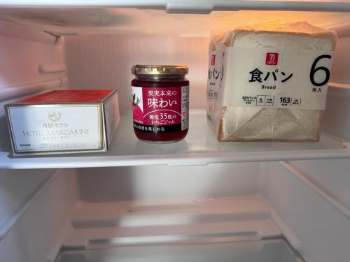 a refrigerator with food and a jar of jam and cheese at お宿花水木 in Nagasaki