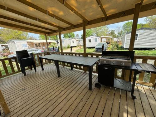 - une terrasse couverte avec une table de pique-nique et un grill dans l'établissement Un toit sur le bassin Bungalow solaire, à Lège-Cap-Ferret