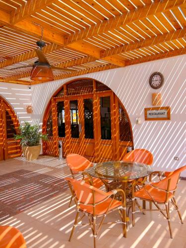 a patio with a glass table and chairs at Beach safari nubian resort in Marsa Alam City