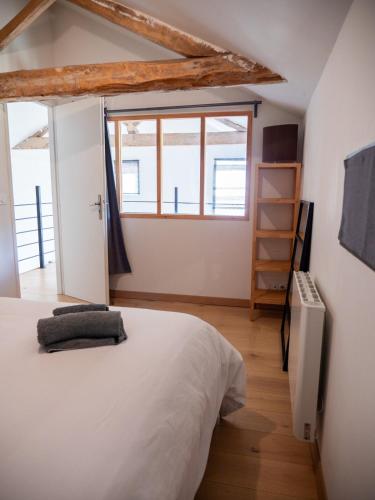 une chambre avec un lit blanc et une fenêtre dans l'établissement Maison vintage 1930 au vert, charme et confort, à Sadirac