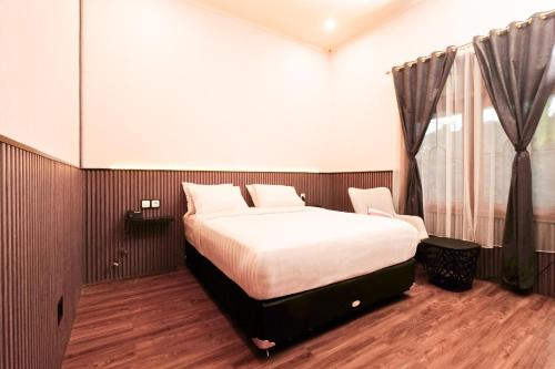 a bedroom with a bed and a window at Berlian Abadi Hotel by Sinergi in Banyuwangi
