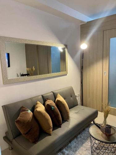 a living room with a couch with pillows on it at Shell Residences MOA by Kirstie in Manila