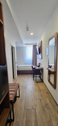 a living room with a table and a mirror at Hotel Villa Sophia in Cologne
