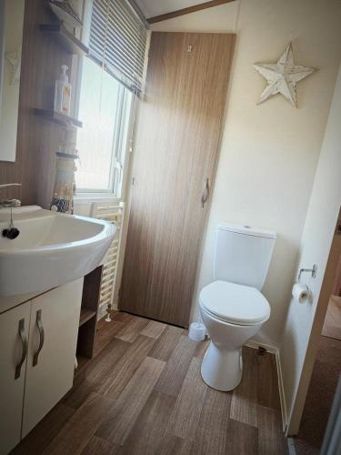 a bathroom with a white toilet and a sink at Modern caravan Robin Hood Rhyl in Rhyl