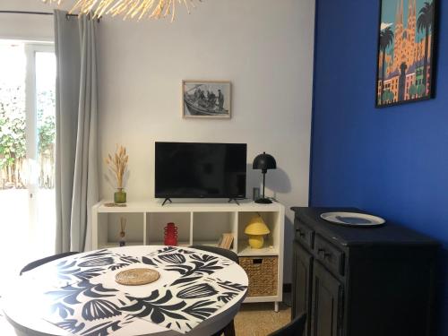 un salon avec une table et une télévision dans l'établissement Ancienne maison de pêcheurs, à Port-la-Nouvelle