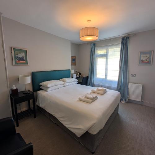 a bedroom with a large bed with two towels on it at The White Rock Hotel in Hastings