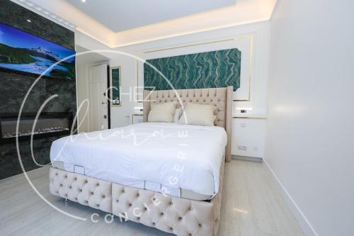 une chambre avec un grand lit blanc dans une pièce dans l'établissement Your suite Champs Elysées calm and stylish, à Paris