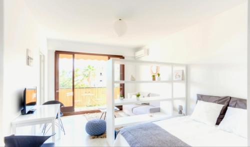 une chambre blanche avec un lit et un bureau dans l'établissement Grand Studio proche Croisette, à Cannes