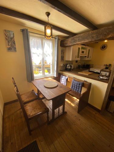 Il comprend un salon avec une table en bois et une cuisine. dans l'établissement The Bell`s End Cottage, à Notre-Dame-du-Touchet